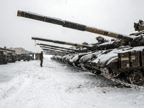 An Ukrainian soldier stands in front of tanks parked in their base near Klugino-Bashkirivka, in the Kharkiv region of Ukraine on January 31, 2022.