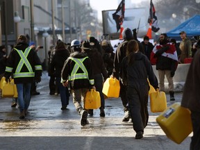 People carry jerry cans near Parliament Hill as demonstrators continue to protest vaccine mandates on February 7, 2022.