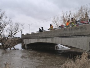 Concerned local residents helped firefighters keep an eye on a section of Whirl Creek from a bridge on Road 160, near Frank Street, in Mitchell on Sunday March 6, 2022. A girl, 10, had fallen through ice hours earlier. Chris Montanini/Stratford Beacon Herald