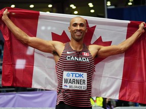 Londoner Damian Warner holds the Canadian flag as he celebrates winning the men's heptathlon event at the world indoor track and field championships in Serbia on March 19, 2022. REUTERS /Aleksandra Szmigiel