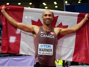 Londoner Damian Warner holds the Canadian flag as he celebrates winning the men's heptathlon event at the world indoor track and field championships in Serbia on March 19, 2022. (REUTERS /Aleksandra Szmigiel)