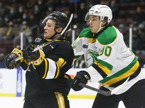 London Knights' Landon Sim, right, checks Sarnia Sting's Max Namestnikov in the back during the first period at Progressive Auto Sales Arena in Sarnia on Wednesday, March 9, 2022. (Mark Malone/Postmedia Network)