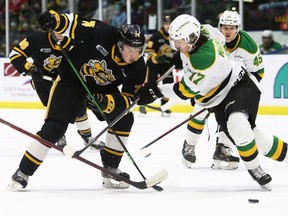 Sarnia Sting's Ethan Ritchie (74) tries to get past London Knights player Ethan MacKinnon (17) in the first period at Progressive Auto Sales Arena in Sarnia on Sunday, March 13, 2022. Mark Malone/Chatham Daily News/Sarnia Observer