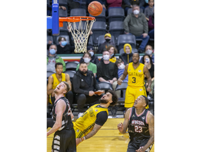 London Lightning's Jermaine Haley watches his shot while falling backwards during their match against Windsor Express at Budweiser Gardens in London on Sunday March 13, 2022. Also watching are team mate Chris Jones (3) and Express players Tanner Stuckman ( left) and Billy White. The Lightning won the game, 123-104. Derek Ruttan/The London Free Press