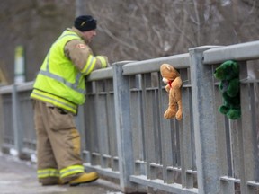 A firefighter scans Whirl Creek from Mitchell's Wellington Street bridge on Tuesday, March 8, 2022, as crews search the fast-moving waterway for a third day for any sign of a 10-year-old girl who had fallen through the ice.  (Derek Ruttan/The London Free Press)