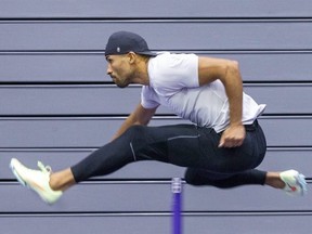 Damian Warner clears a hurdle while training at Western University in London on Thursday March 10, 2022. (Derek Ruttan/The London Free Press)