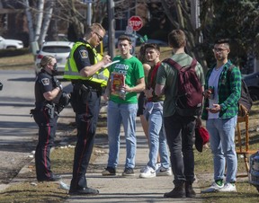 London police speak to St. Patrick's Day revelers on Broughdale Avenue. (Derek Ruttan/The London Free Press)