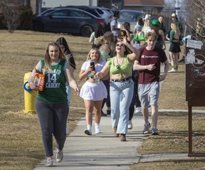 People celebrating St. Patrick's Day walk on Farnsborough Crescent towards Fleming Drive near Fanshawe College in London. (Derek Ruttan/The London Free Press)