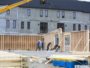 Workers build more housing at the northwest corner of Sunningdale Road and Richmond Street in London on Monday, March 21, 2022.  (Derek Ruttan/The London Free Press)