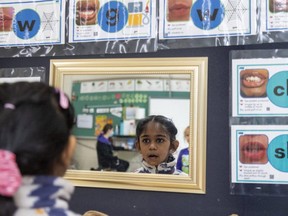 Barthi Arun, 7, practises making sounds at the sound wall at Stoneybrook elementary school in London. The photos show children how to sound out the letters and combinations, and they can use the pictures to figure out how to spell words. (Mike Hensen/The London Free Press)