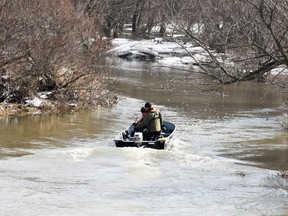 Members of an OPP search and recovery team patrol Whirl Creek east of Road 160 in Mitchell Wednesday for a missing 10-year-old girl who fell through the ice on Sunday. (Andy Bader/Postmedia Network)
