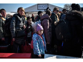 People wait to board buses after crossing from Ukraine into Poland at the Medyka border crossing on March 15. More than three million people have now fled Ukraine since Russia invaded on Feb. 24.
