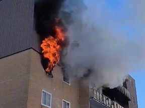 Flames shoot from a window of an apartment building on Lisgar Avenue in Tillsonburg. Firefighters rescued several people from the upper floors of the building after the fire was spotted by a passerby at about 7 a.m. on Tuesday March 8, 2022. OPP Twitter photo