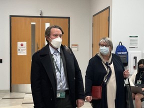 Chris Mackie, left, medical officer of health for Middlesex-London who is on leave, leaves a health unit board meeting Thursday, March 3, 2022, after meeting with members behind closed doors. (Jennifer  Bieman/The London Free Press)