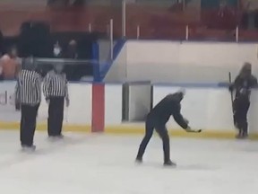 A minor hockey coach is shown whipping a broken stick blade toward two referees in a cellphone video taken during a game at Talbot Gardens in Simcoe on March 2, 2022. A provincial minor hockey association is investigating the incident. (Screengrab/supplied)
