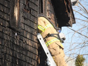 A Sarnia firefighter looks Wednesday into a home at the corner of Lochiel and Euphemia streets that was damaged by fire late Tuesday night.