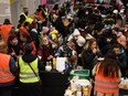 People fleeing Russia's invasion of Ukraine obtain food and other necessities at Berlin's central station in Germany on March 9.