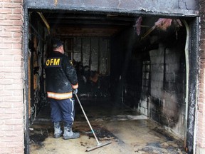 Clive Hubbard, an investigator with the Ontario Fire Marshal's office, investigates the garage of a heavily damaged Lanark Crescent townhouse unit on Monday, April 4, 2022 in Sarnia. Terry Bridge/Sarnia Observer/Postmedia Network