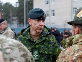 General Wayne Donald Eyre (C), chief of Canadian Defence Staff (CDS) talks with soldiers at a military base, north east of Riga, Latvia, on March 8, 2022. (Photo by Toms Norde / AFP)