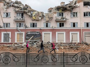 People walk along a street in front of the destroyed Hotel Ukraine, as Russia's invasion of Ukraine continues, in Chernihiv, Ukraine, April 6, 2022. REUTERS/Marko Djurica