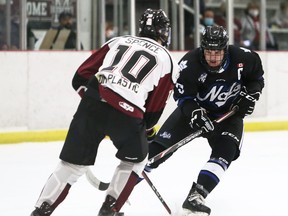 London Nationals captain Jeff Burridge, right, is defended by Chatham Maroons player Craig Spence in overtime before scoring the winning goal at Chatham Memorial Arena in Chatham on Sunday, Feb. 20, 2022. Mark Malone/Chatham Daily News/ Postmedia