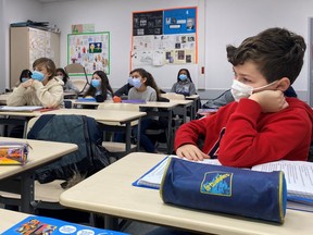 Schoolchildren wear masks in a classroom on January 7, 2022. REUTERS