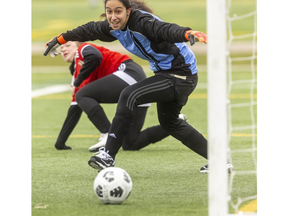 Westminster Wildcats goalie Adim Abdel Kader lunges toward the ball as St. Thomas Aquinas player Katie Bell's kick nears the goal line. It would be touched in by STA en route to a victory. Photo taken at City Wide field on Wednesday April  27, 2022. Mike Hensen/The London Free Press)