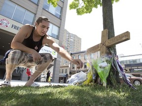 Brodie Elliott sprinkles Indian tobacco at a memorial for homicide victim Dereck Szaflarski at the corner of Piccadilly and Richmond streets in London on May 28, 2018. A trial began Monday for the man accused of killing Szaflarski during a confrontation. (London Free Press file photo)