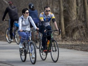 Zeinab Jadfarlavasani and Alejandro Santa Cruz get out for a ride on their bikes on the pathways through Gibbons Park. 
(Mike Hensen/The London Free Press)