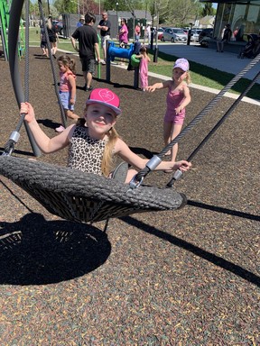 Blakely Gibson, 7, gets a push from her sister Dani, 6, at the opening of the East Lions Community Centre on Saturday, May 14, 2022. (Norman De Bono/The London Free Press)