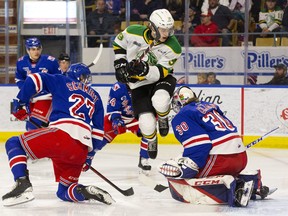 London Knights player Max McCue leaps out of the way of a shot between Kitchener Rangers player Roman Schmidt and goalie Pavel Cajan during their game at The Aud in Kitchener on Tuesday May 3, 2022. Derek Ruttan/The London Free Press