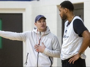 Lightning head coach Doug Plumb answers a question on timing from centre Amir Willams. (Free Press files)