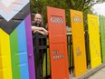 Canon Kevin George of St. Aidan's Church on Oxford Street West stands with a display of doors intended to mark Pride month in June. The doors, in the colours of the Pride flag, say in English and French: God's Doors Are Open To All. (Mike Hensen/The London Free Press)