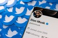 Elon Musk's Twitter profile is seen on a smartphone placed on printed Twitter logos in this picture illustration taken April 28, 2022. REUTERS/Dado Ruvic/Illustration/File Photo