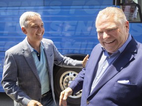 Jerry Pribil, the Progressive Conservative candidate in London North Centre, left, greets party leader Doug Ford as he gets off the campaign bus in London on Thursday, May 12, 2022. (Mike Hensen/The London Free Press)