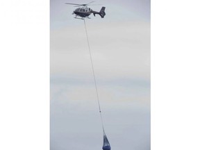 An OPP helicopter lifts a freezer from the beach below a Lake Erie bluff east of Port Burwell on Tuesday, May 7, 2019. Earlier, the helicopter lifted a body from the beach. Derek Ruttan/The London Free Press