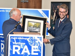 Outgoing Perth-Wellington MPP Randy Pettapiece (left) hands newly-elected Matthew Rae a print that hung in his office with a "Persistence" label, something that Rae said he will hang in his office after being elected June 2. (ANDY BADER/Postmedia Network)