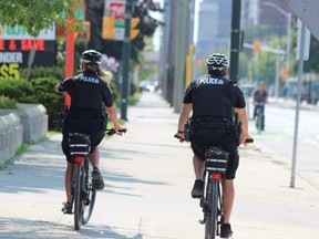 Two London police officers cycle down Dundas Street. (DALE CARRUTHERS / THE LONDON FREE PRESS file photo)