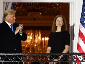 In this file photo taken on October 26, 2020 US President Donald Trump applauds Judge Amy Coney Barrett on the Truman Balcony after she was sworn in as a US Supreme Court Associate Justice during a ceremony on the South Lawn of the White House, in Washington, DC. - The US Supreme Court on June 24, 2022 struck down the right to abortion in a seismic ruling that shredded five decades of constitutional protections and prompted several right-leaning states to impose immediate bans on the procedure. "God made the decision," said former Republican president Donald Trump in praising the court's ruling. The ruling was made possible by Trump's nomination of three conservative justices - Neil Gorsuch, Kavanaugh and Amy Coney Barrett. (Photo by BRENDAN SMIALOWSKI/AFP via Getty Images)