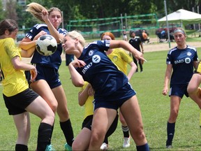 Players on the London Whitecaps, wearing blue, battle Aurora FC players for an airborne ball during the U17 semifinal of their organization's all-girl tournament on Sunday June 12, 2022 at the North London Fields. The Whitecaps won 4-2. DALE CARRUTHERS / THE LONDON FREE PRESS