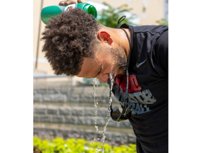 City of London worker Bryce Twohey cools off after planting flowers in a bed outside Budweiser Gardens in London on Wednesday June 15, 2022. Mike Hensen/The London Free Press