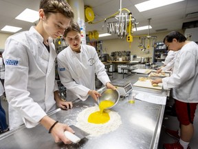 Kayden Polmateer and Daphne Laidlaw mix eggs and flour to make fresh pasta dough in a Clarke Road secondary school program where the high schoolers are taught how to make healthy lunches for elementary students in London. (Mike Hensen/The London Free Press)
