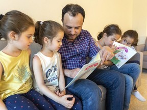 Nader Alrawi reads with four of his daughters: Lamar, 5, Rand, 5, Raghad, 9, and Rima, 5. Alrawi's proposal to create a little library of Arabic books was one of 79 projects in the running in the city's neighbourhood decision-making contest. Photograph taken on June 17, 2022. 
Mike Hensen/The London Free Press