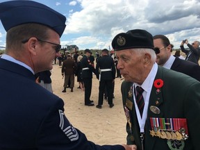 DDay veteran James Parks, 96, is pictured during his last trip to Normandy in 2019. He is shaking hands with U.S. service man Chief Master Sgt. Brent Bixby