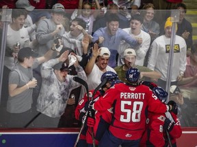 Windsor Spitfires defenceman Andrew Perrott celebrates with his teammates after a goal. The longer he plays, the more chances Perrott and his teammates have to showcase their talent to scouts.