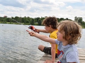 Theo Murray 3, points to an incoming Kayak while his brother, Gavin, 6, prepares to cast his rod in Fanshawe Lake at Fanshawe Conservation Area on Saturday July 2, 2022. (Calvi Leon/The London Free Press)