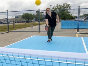 Laura Cooper, marketing coordinator for the London International Airport, volleys a pickleball at the public court they've opened in their parking lot. Photo taken on Monday July 18, 2022. Mike Hensen/The London Free Press/Postmedia Network