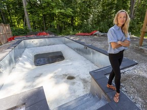 Krista Peters of Strathroy stands next to her partially built pool, courtesy of a new installer, after her original pool installer left her with debts and a huge hole in the ground behind their home. Photograph taken on Wednesday, June 29, 2022.  (Mike Hensen/The London Free Press)