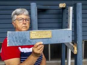 Beth McKinlay of Holy Trinity St. Stephen's Memorial Anglican Church on Southdale Road in London shows the small plaque that states Ray Barker donated a bell in 1968. The 360-kilogram vintage CN  locomotive bell was stolen from the church some time between Sunday and Monday this week. (Mike Hensen/The London Free Press)