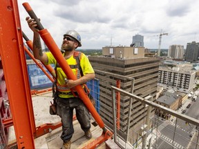 Dylan Churchill of EllisDon constructs a wall 19 floors up at 131 King St. as construction on a York Developments tower continues. The tower, just across from Covent Garden Market, will top out at 31 floors with 266 apartments in downtown London. Photograph taken on Friday July 8, 2022. (Mike Hensen/The London Free Press)